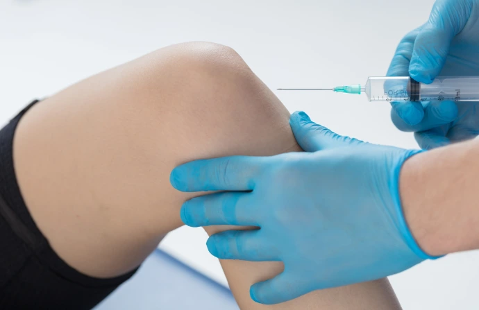 Profesional de la salud con guante azul aplicando un dispositivo médico al paciente